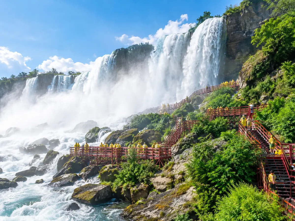 Rote Holzstege und Treppen am Fuß eines gewaltigen Wasserfalls